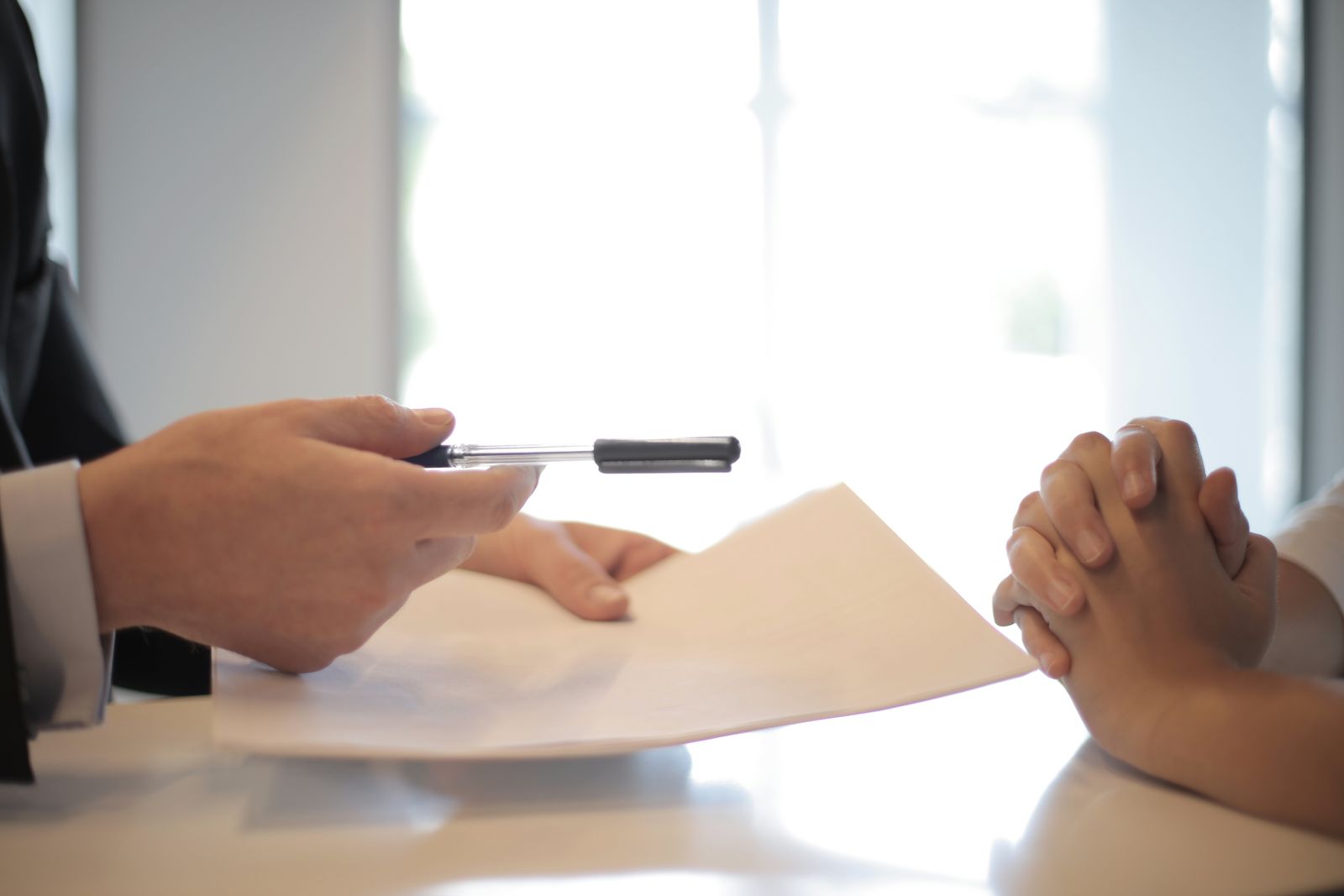 Two people reviewing a paper document at a desk before preparing an application